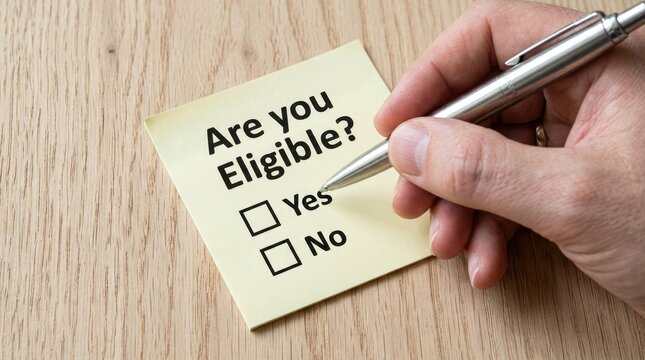 Human hand holding silver pen choosing yes on yellow sticky note regarding eligibility status query question
