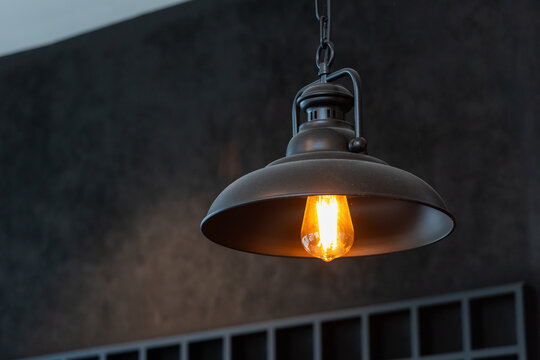 Classic industrial lamp with exposed bulb illuminates dim room