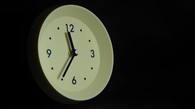 Tme lapse video of a clock time passing over a day to night on black background.