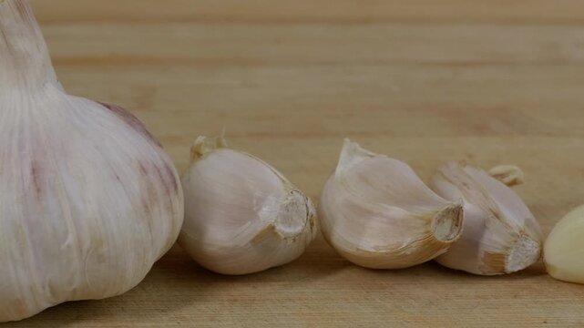 Peeled garlic cloves arranged next to freshly minced garlic paste.