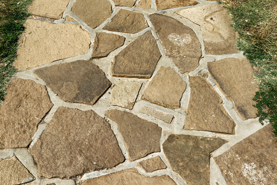 Irregular natural stone flagstone pathway in garden top view texture