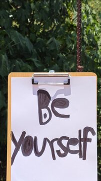 Motivational Note BE Yourself with Green Foliage Background
