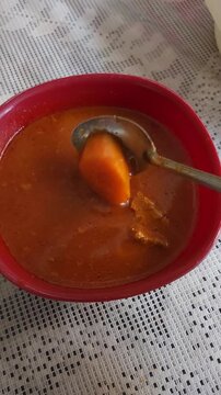 Bowl of Beef Stew with Carrots in Savory Red Broth
