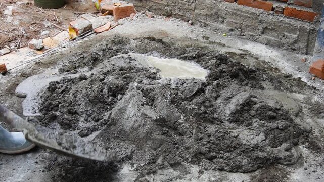 Slow Motion Shot of Worker Mixing Wet Concrete Mortar with Shovel