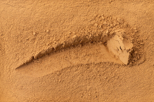 Still Life Texture of Cracked Warm Brown Arid Soil with Diagonal Fissure