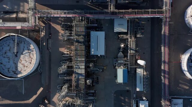 Aerial view of oil refinery with complex network of pipes, storage tanks, and industrial structures