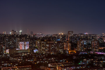 Obraz premium A panoramic view of Beijing's cityscape at night, with thousands of lights illuminating residential buildings.