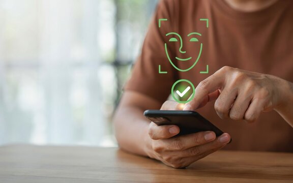 Closeup of a person using facial recognition technology on a smartphone