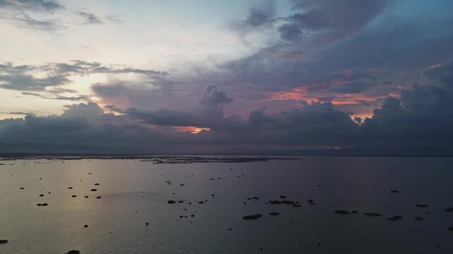 Aerial View of Dramatic Sunset Over Water with Dark Clouds