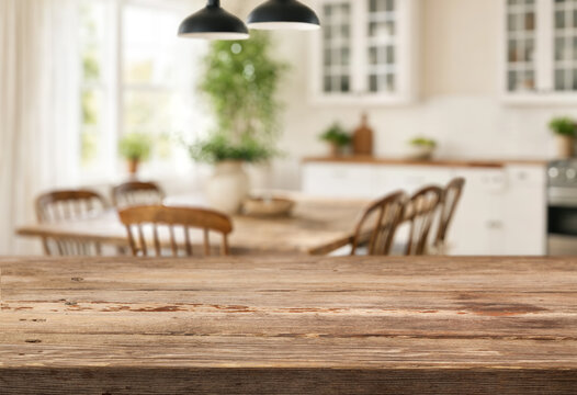 empty wooden surface on foreground and cozy kitchen-living room on background