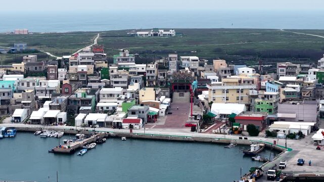 Aerial View Of Coastal Village, Traditional Temple, And Harbor With Boats On Jibei Island, Penghu, Taiwan. sideways shot