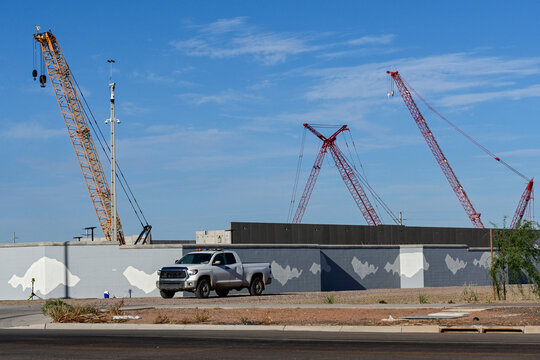 Security truck patrols the perimeter of a data center under construction with cranes, illustrating site security, AI infrastructure, commercial development, and construction activity