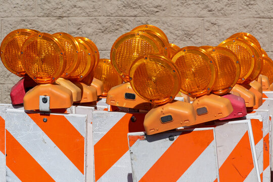 Portable traffic barricades with flashing warning lights staged for roadway construction, illustrating traffic control, work zone safety, and transportation infrastructure