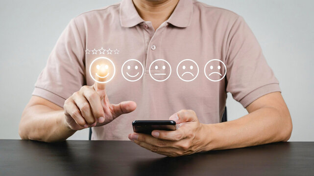 Man providing positive customer feedback and rating using digital smiley icons on a smartphone