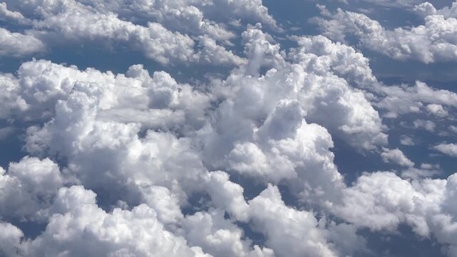 Airplane window view of puffy white clouds from above