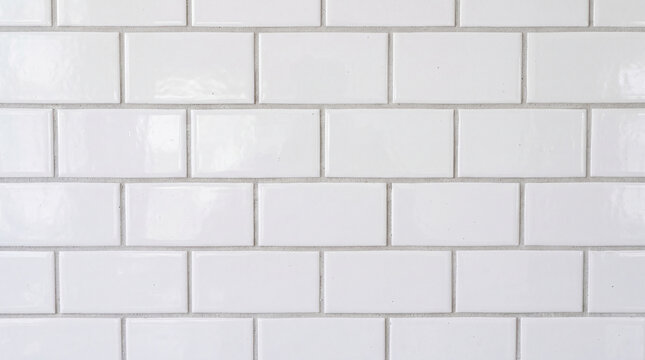 Glossy white subway tile wall with pale grout lines in a clean grid