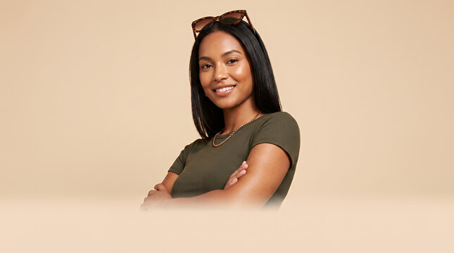 Young woman wearing sunglasses with confident pose against neutral studio background