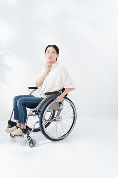 車椅子に乗る考える女性