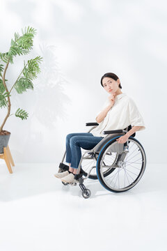 車椅子に乗る考える女性
