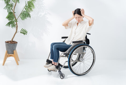 車椅子に乗る落ち込む女性