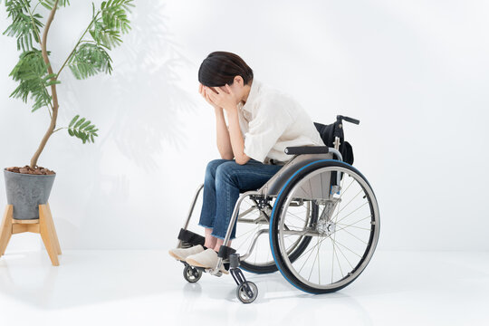車椅子に乗る落ち込む女性