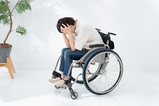 車椅子に乗る落ち込む女性