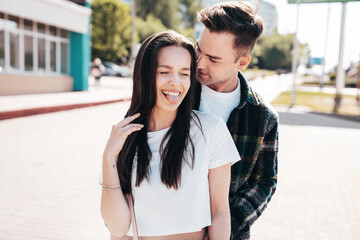 Fototapeta premium Smiling beautiful woman and her handsome boyfriend. Woman in casual summer clothes. Happy cheerful family. Female having fun. Sexy couple posing in the street at sunny day