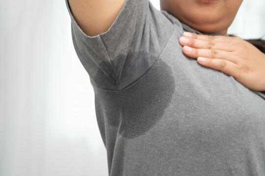 Sweaty underarms, Asian woman with sweat on clothes under armpit.