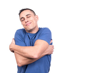 Obraz premium Happy man hugging himself as he closes his eyes