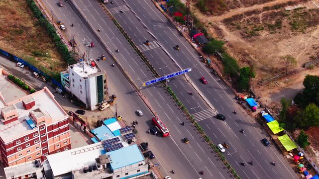 Multi-Lane Indian Highway with sign boards arch and Moving Vehicles at bhel, chanda nagar, hyderabad, telangana, india. day time, static shot, drone shot, 4k.