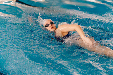 Fototapeta premium Female athlete swimming freestyle strokes in pool