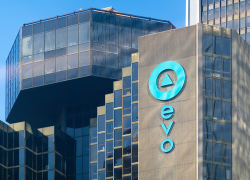 Montreal, Quebec, Canada. July 26, 2026. Low angle view of the blue evo logo on a concrete skyscraper against a clear blue sky.
