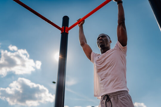 Determined athlete performing calisthenics pull-ups for strength