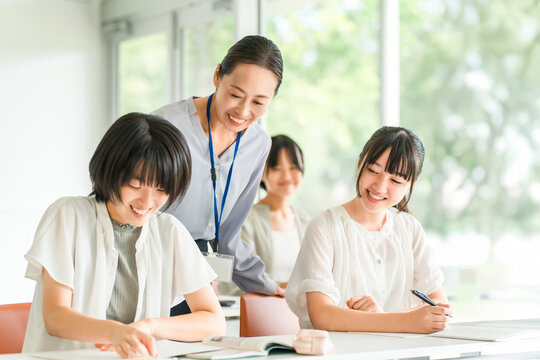 Elementary school children studying at cram schools/after-school programs, attending classes at school, and summer school, and their female instructors.