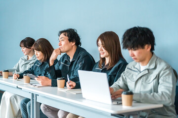 Fototapeta premium Employees and staff (businessmen and businesswomen) wearing work clothes at small and medium-sized enterprises such as factories and construction companies.