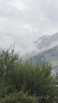 Zen Stones at Cave Entrance Overlooking Moody Foggy Mountains in the Rain (Vertical)