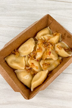 Semi-finished Varenyky products placed in a cardboard box ready for cooking or serving in a simple setting