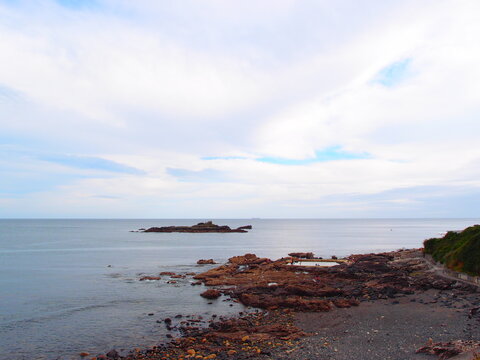 Rocky coastline with natural tidal pool under cloudy sky