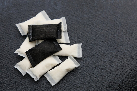 Different types of snus pouches are arranged on a dark surface, showcasing the product design and nicotine content clearly