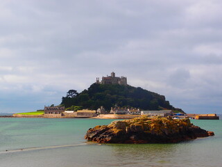Historic island castle across calm water under cloudy sky © Tib