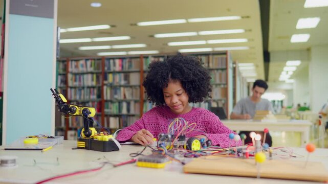 African American young girl student study on robot project in library. 