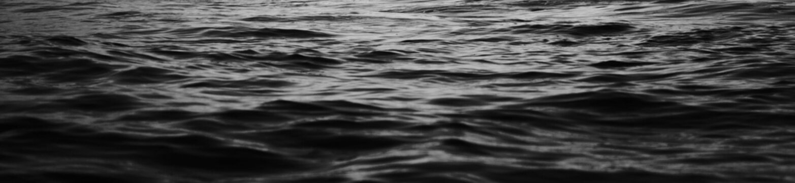 Black water sea wave. black water banner, cover page and surface of dark nature background. Black water texture. ripple effect on surface sea water in black and white color. wave background.