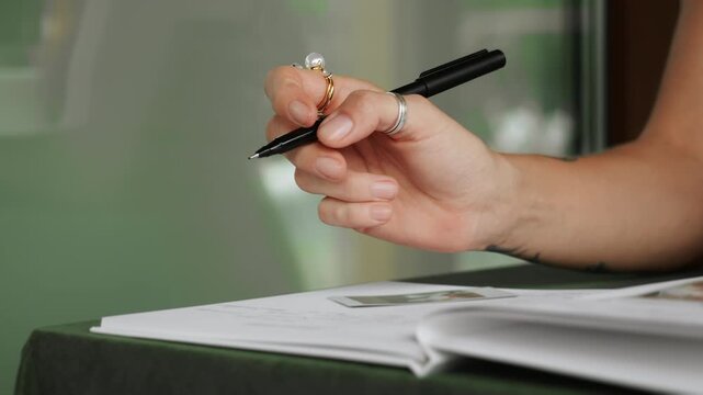 Close-up of a womans hand writing in a guest book or document. Elegant signing, registration or note-taking concept suitable for business, events, hospitality and administration themes.