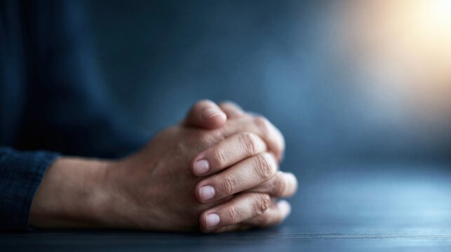 Close up of hands clasped together in prayer, conveying hope, faith, and contemplation