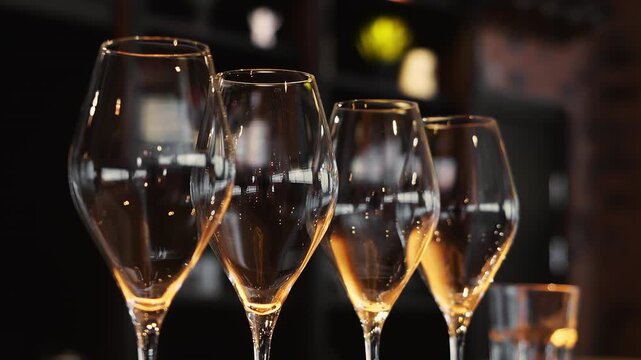 Elegant empty champagne glasses arranged on a bar or restaurant table. Stylish glassware ready for guests at a celebration, reception or fine dining event.