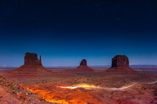 Monument Valley Butte Silhouette at Sunrise with Desert Mist and Vibrant Dawn Sky, Arizona, Utah, USA