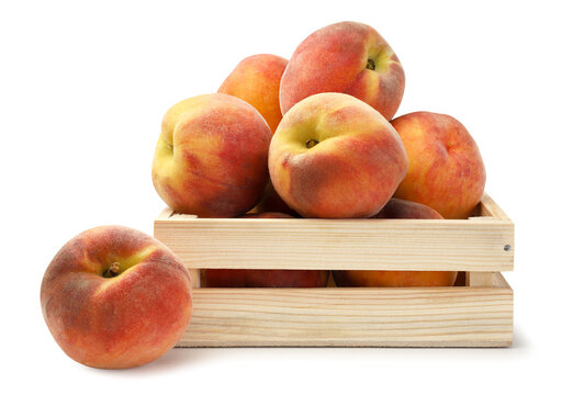 Ripe peaches in a wooden box close-up on a white. Isolated