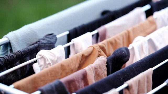 Laundry hanging on a clothes horse outside with grass in the background