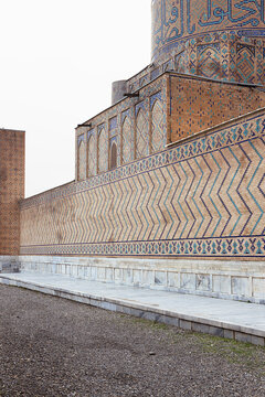 Bibi Khanum Mosque exterior wall detail in Samarkand showing intricate brickwork and turquoise tilework patterns. Ideal for travel publications, cultural heritage materials, and architecture features.