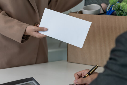 resignation, leave, quit, employee pass on resignation letter to Business owner . staff is lifting a brown paper box that holds personal items. , job placement and vacancies, resignation letter